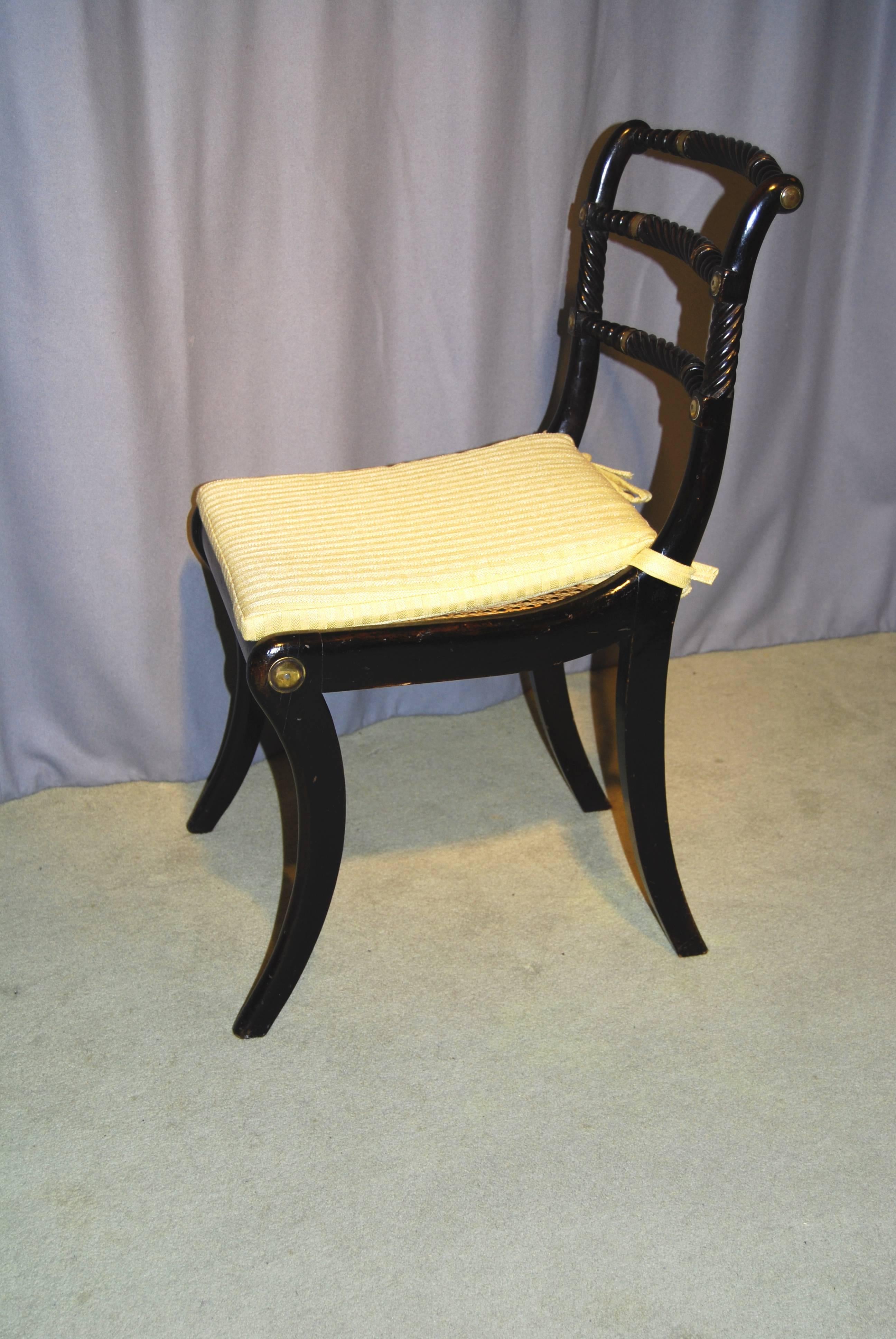 A fine quality Regency period ebonised “Trafalgar” chair with a triple rope-back with brass collars and raised on sabred legs.

This model of chair with the ropes and sabres symbolising naval power was ordered by Admiral Nelson before the battle