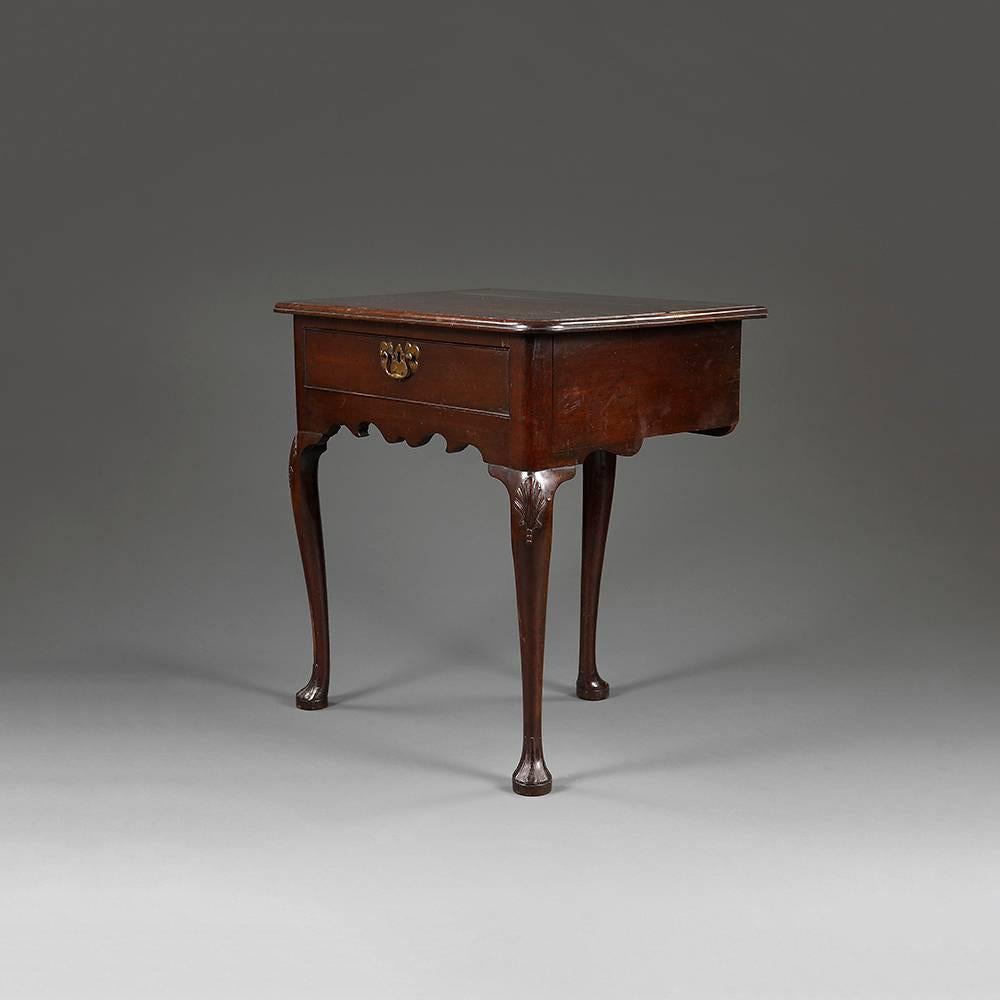 An unusual George II period mahogany lowboy with plain top over single drawer with original handles over shaped frieze on cabriole legs terminating in a pad foot.

English, circa 1740
Unusually this piece has only three legs rather than four, and