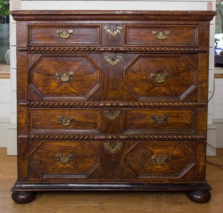 A charming early 18th century simulated oyster veneered walnut painted chest of drawers in beech, with four drawers in unusual configuration with one shallow drawer over one deeper drawer and then repeated. Between each set of drawer a carved rope