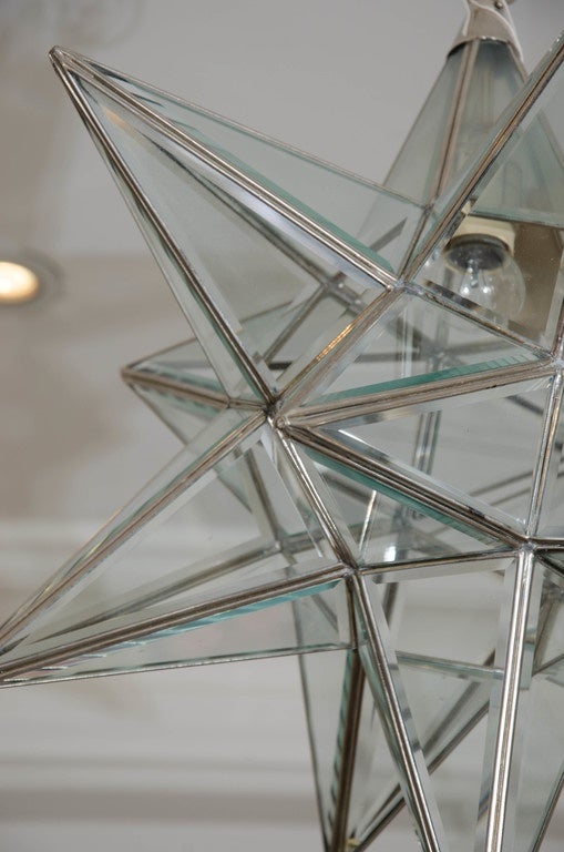 A modern multi faceted clear glass star hanging lantern