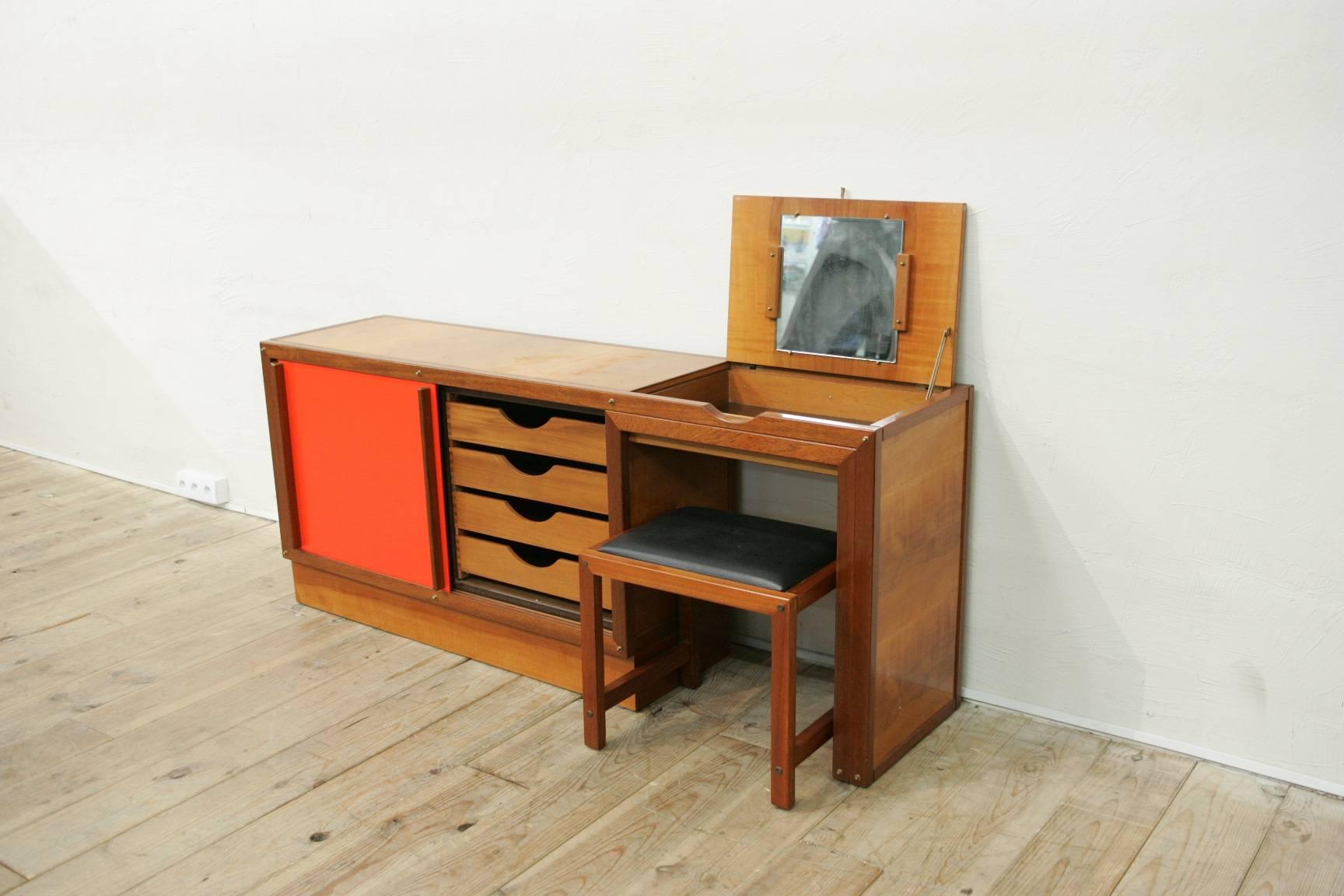 A very interesting sideboard forming a dressing table(with the original stool) by André Sornay in perfect old original condition made of cherry wood ,mahogany(drawers) and doors in corail lacquered "isorel", 1950-1960.