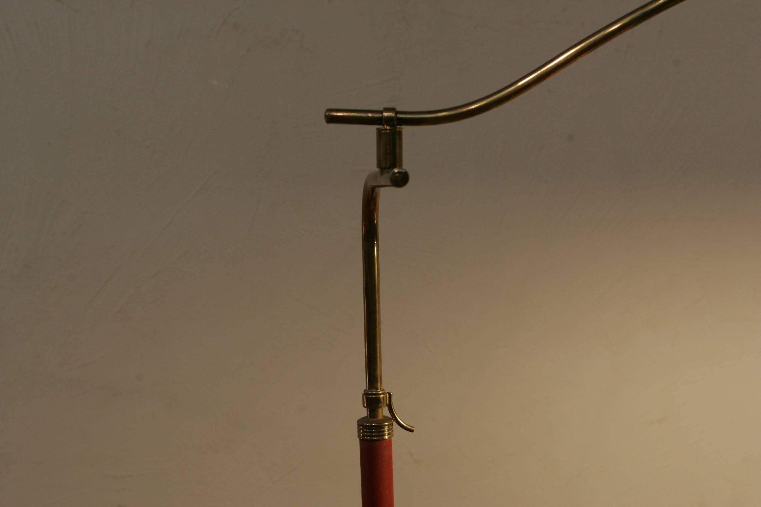 A very nice Italian Mid-Century Modern floor lamp made of brass and red leather. The steel 