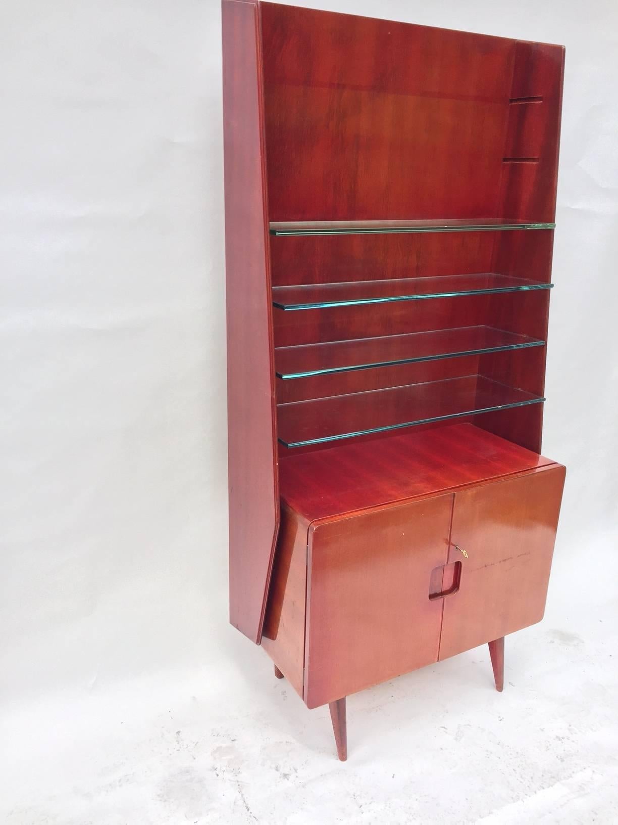  Display cabinet in polished red mahogany with six thick glass shelves and storage on the bottom by Vittorio Valabrega, Italian, 1950s. (Only one is available) 