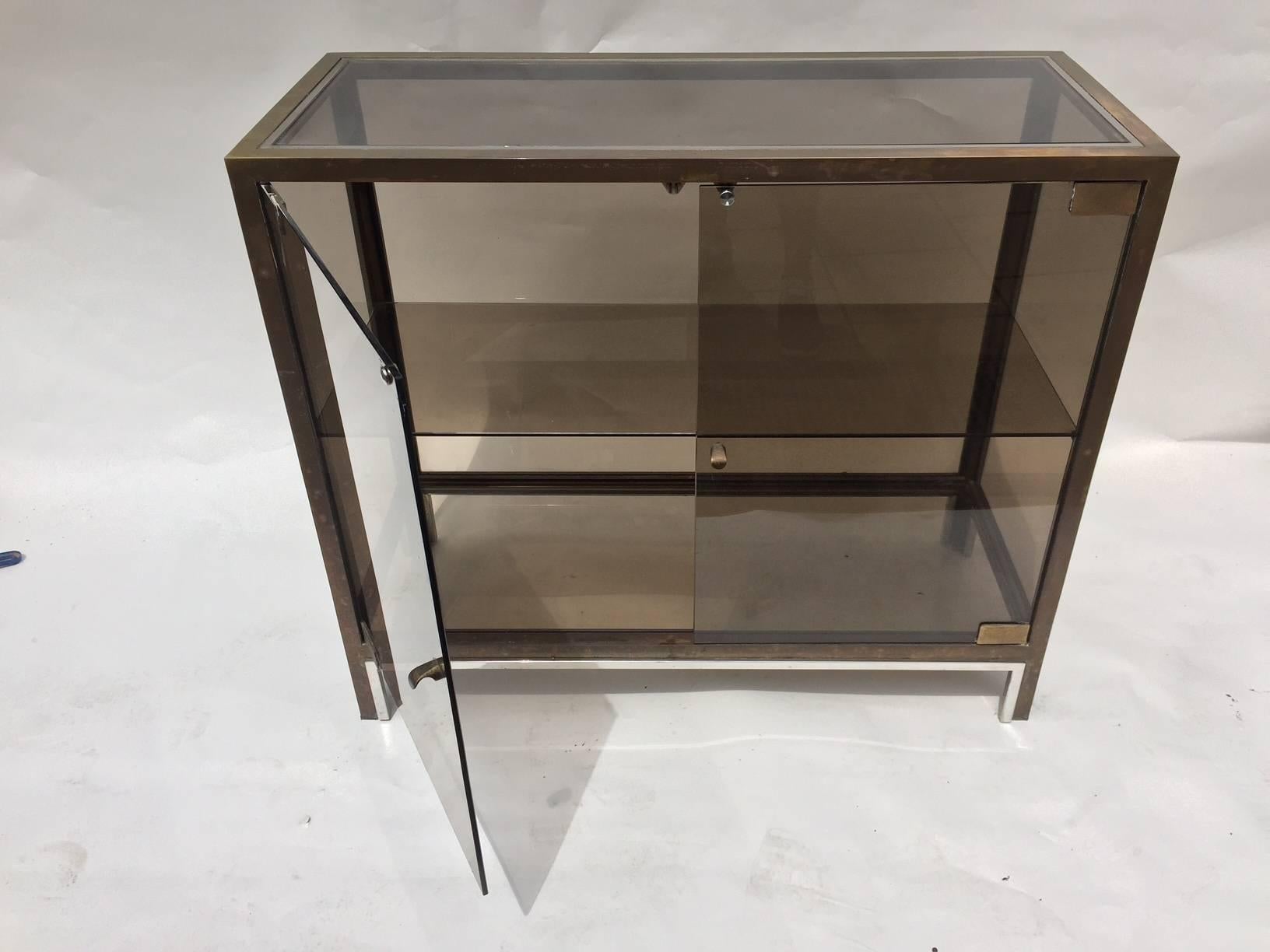 Combination of brass, chrome and smoke glass display cabinet with a shelve inside attributed to Willy Rizzo, Italian, 1960's.