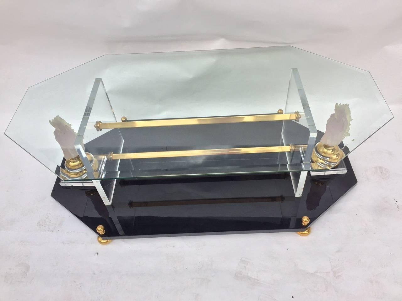 This beautiful coffee table on black lacquered wooden base with decorative brass feet and thick Lucite on each side with supporting by two brass bars in the middle and thick glass top with decorative Lucite horses on each side, Italian, 1970s.