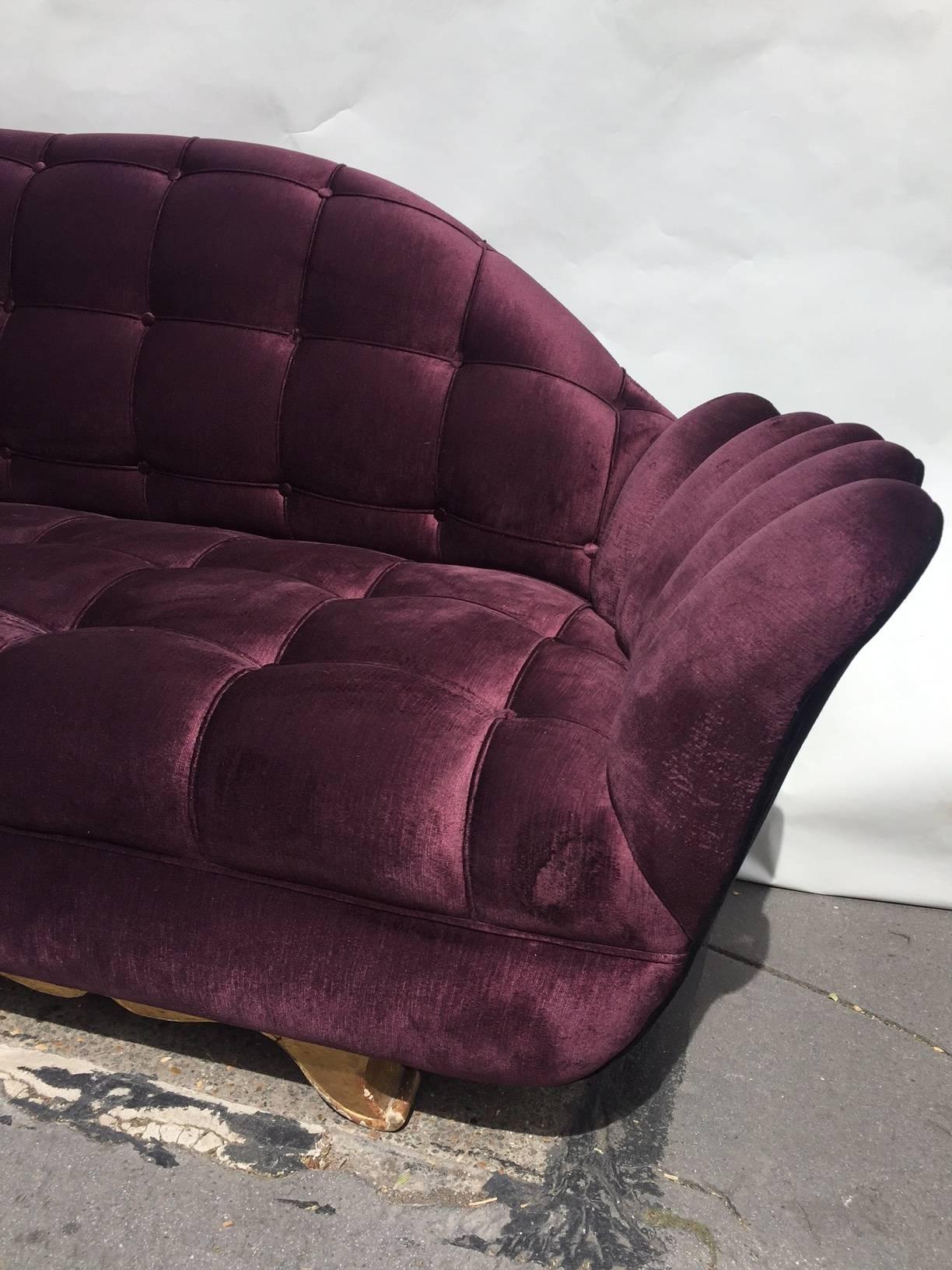 This unusual sofa in very extraordinary shape reupholstered in purple velvet, on the gilt wooden feet, Italy, circa 1940s.