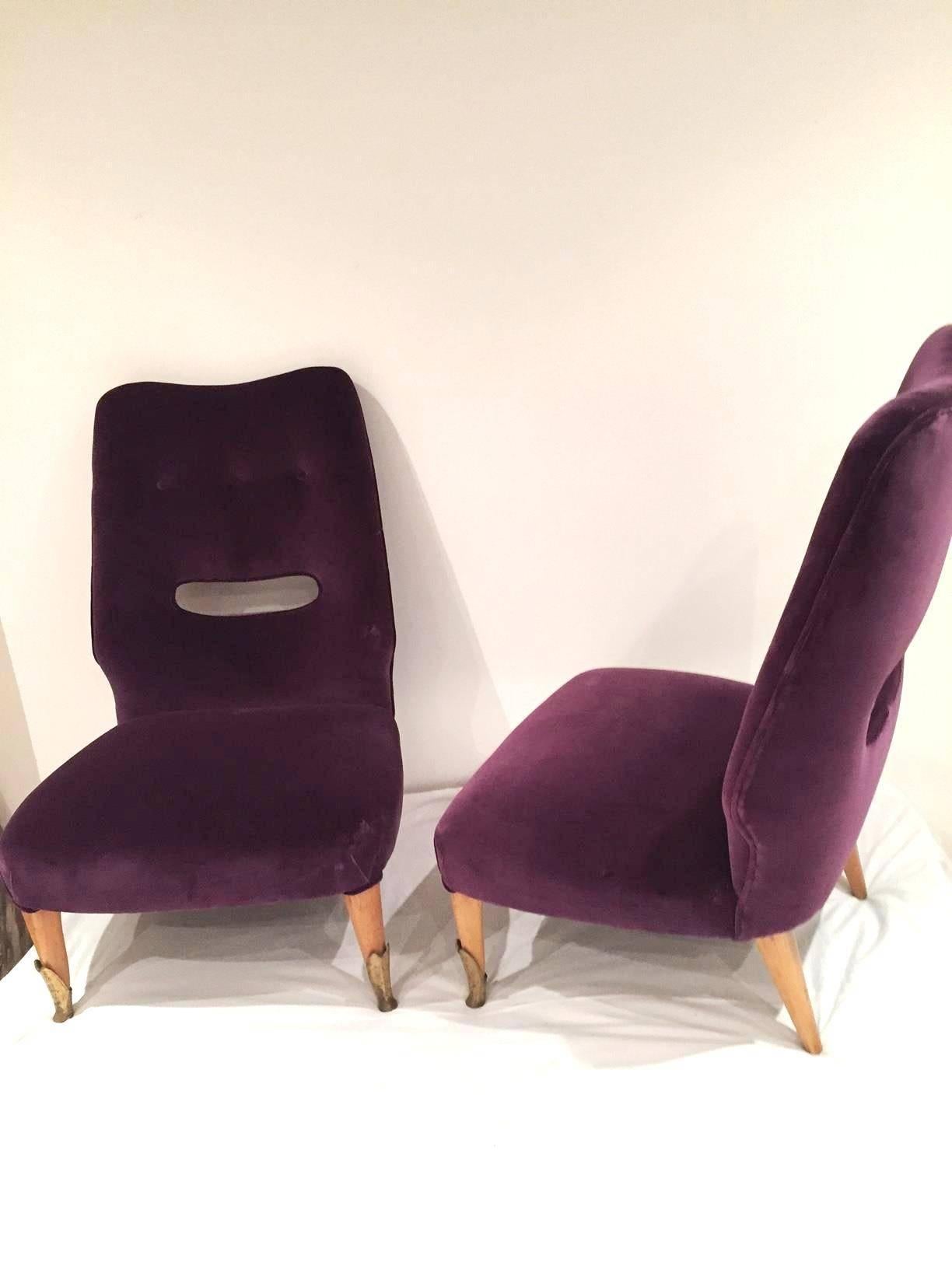 A pair of Italian, 1950s elegant side chairs, with a hole in the rest back, with the light polished feet and the brass sabot, reupholstered in purple velvet.