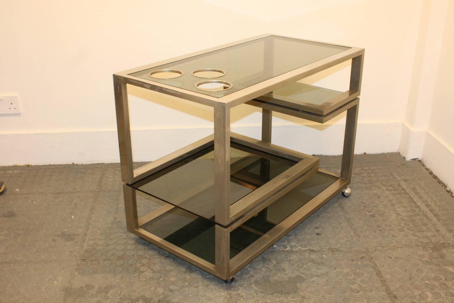 Polished steel four tiers drink cart with three holes for the bottles and removable four glass shelves. Italian 1960s in style of W.Rizzo