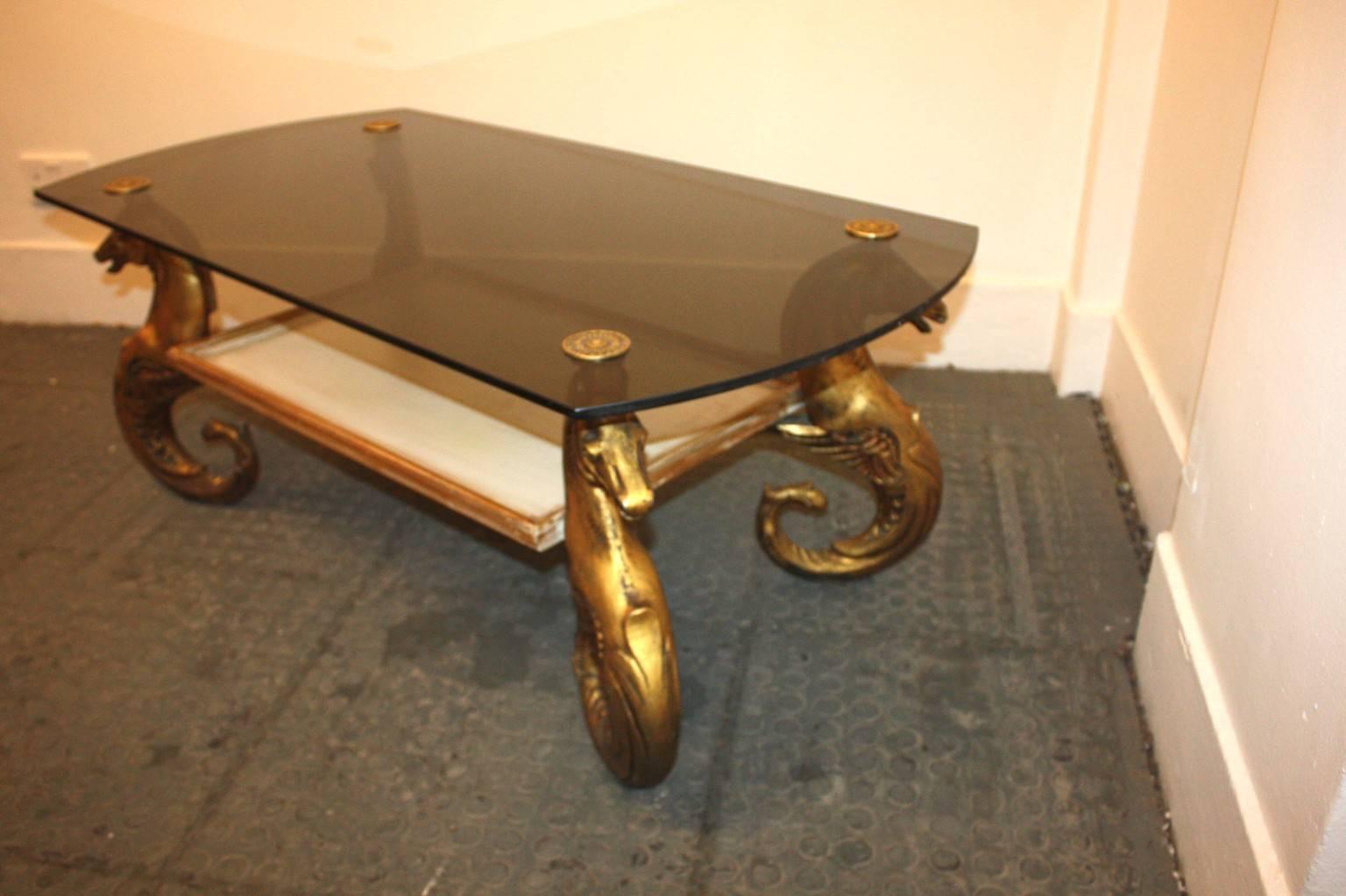 1950s French seahorses coffee table in gilt metal and smoke glass top with a gilt wood and white painted tray on the bottom