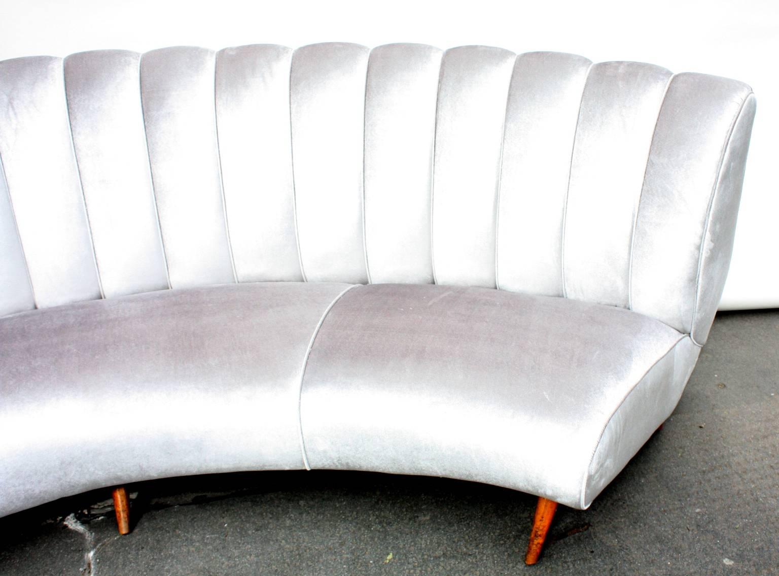 A large impressive curved and scalloped back sofa, reupholstered in silver velvet, in the style of Gio Ponti designed by Isa, 1950s, Italian.