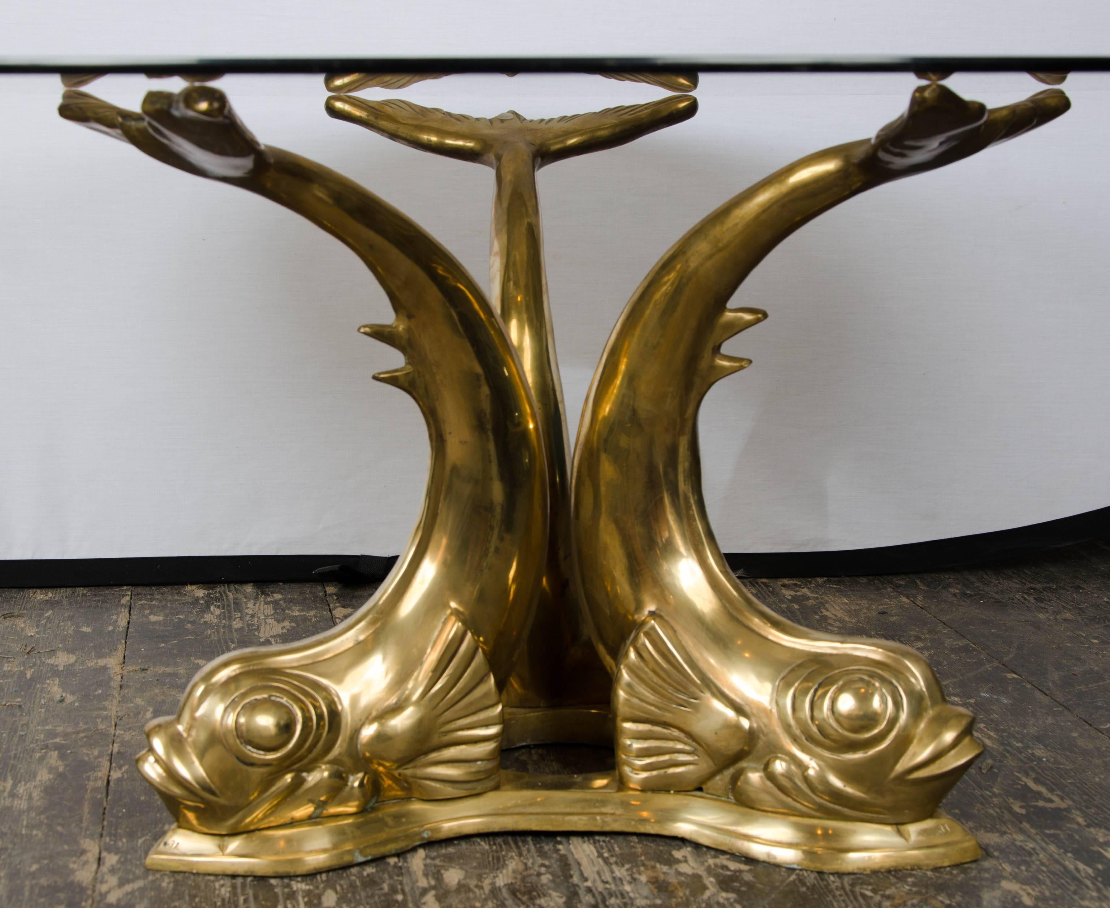 A solid cast bronze finish coffee table with a clear glass top.