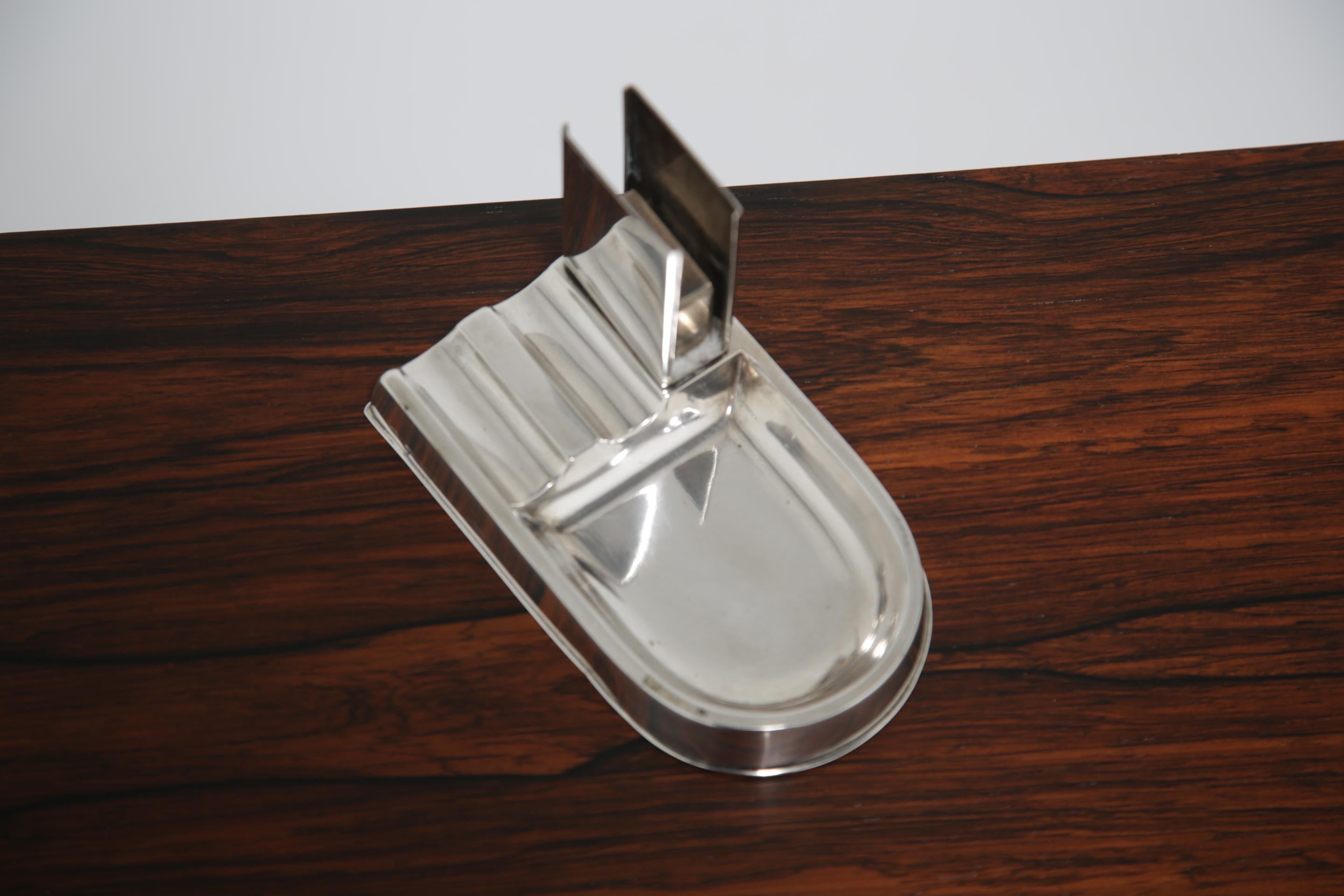 Posacenere ungherese in argento Art Deco con porta fiammiferi, timbrato 800

Questo posacenere ungherese in argento Art Deco con porta fiammiferi integrato è un esempio straordinario di design funzionale dei primi del Novecento. Realizzato in