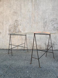 Desk consisting of two wrought-iron trestles and a thick Plexiglas top