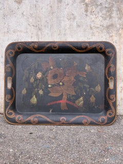 Bandeja de chapa pintada del siglo XIX; presenta algunas pequeñas pérdidas de pintura y arañazos.