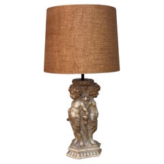 A marble table lamp, probably Italian, depicting three putti holding hands