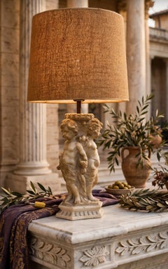 A marble table lamp, probably Italian, depicting three putti holding hands
