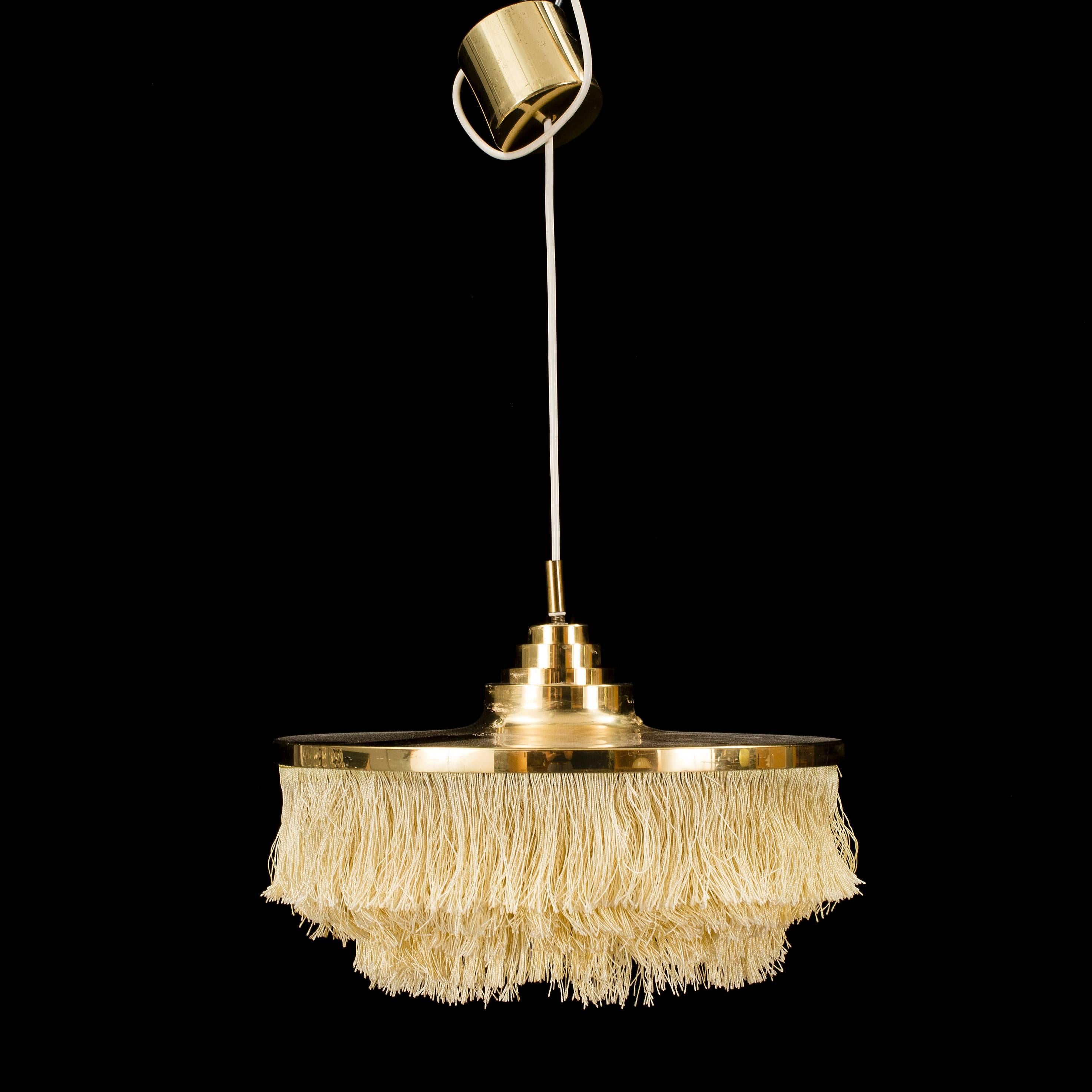 A round chandelier in brass with crème colored fringes by Hans Agne Jakobsson. Made in Sweden by Markaryd, Sweden, early 1970s.