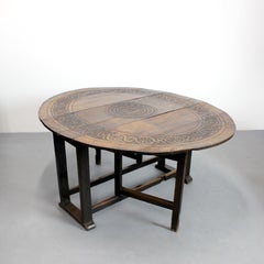 Round drop-leaf table in oak, featuring carved decoration and straight legs