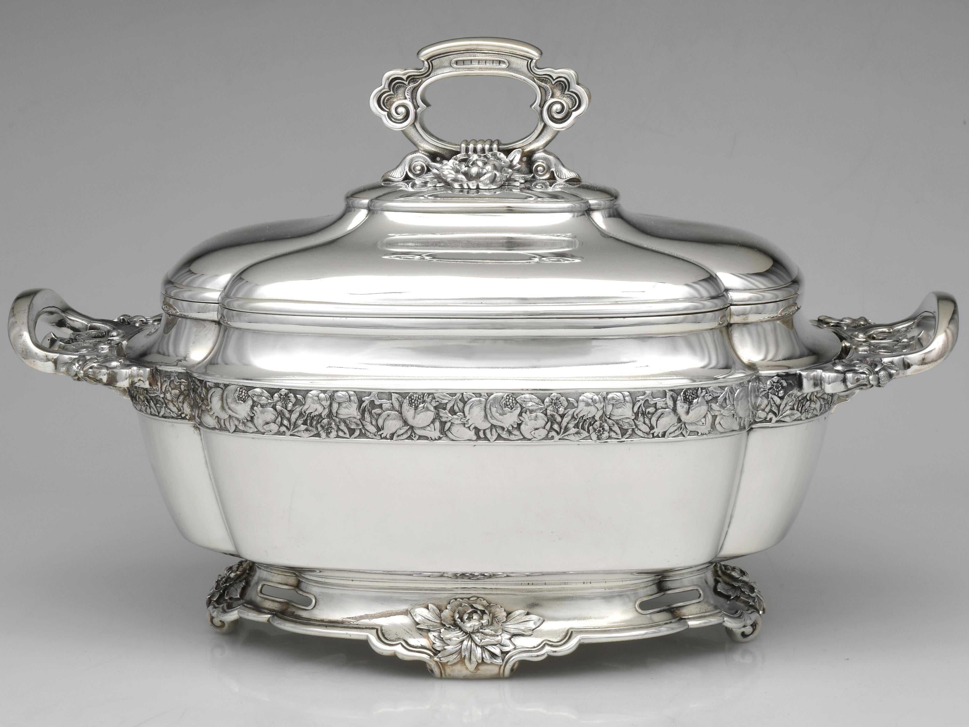Questa zuppiera in argento sterling è un esempio di lavorazione dell'argento in stile Rococò Revival, che celebra l'opulenza e i dettagli intricati. La sua combinazione di motivi naturali, linee curve e ricche decorazioni la colloca saldamente nel