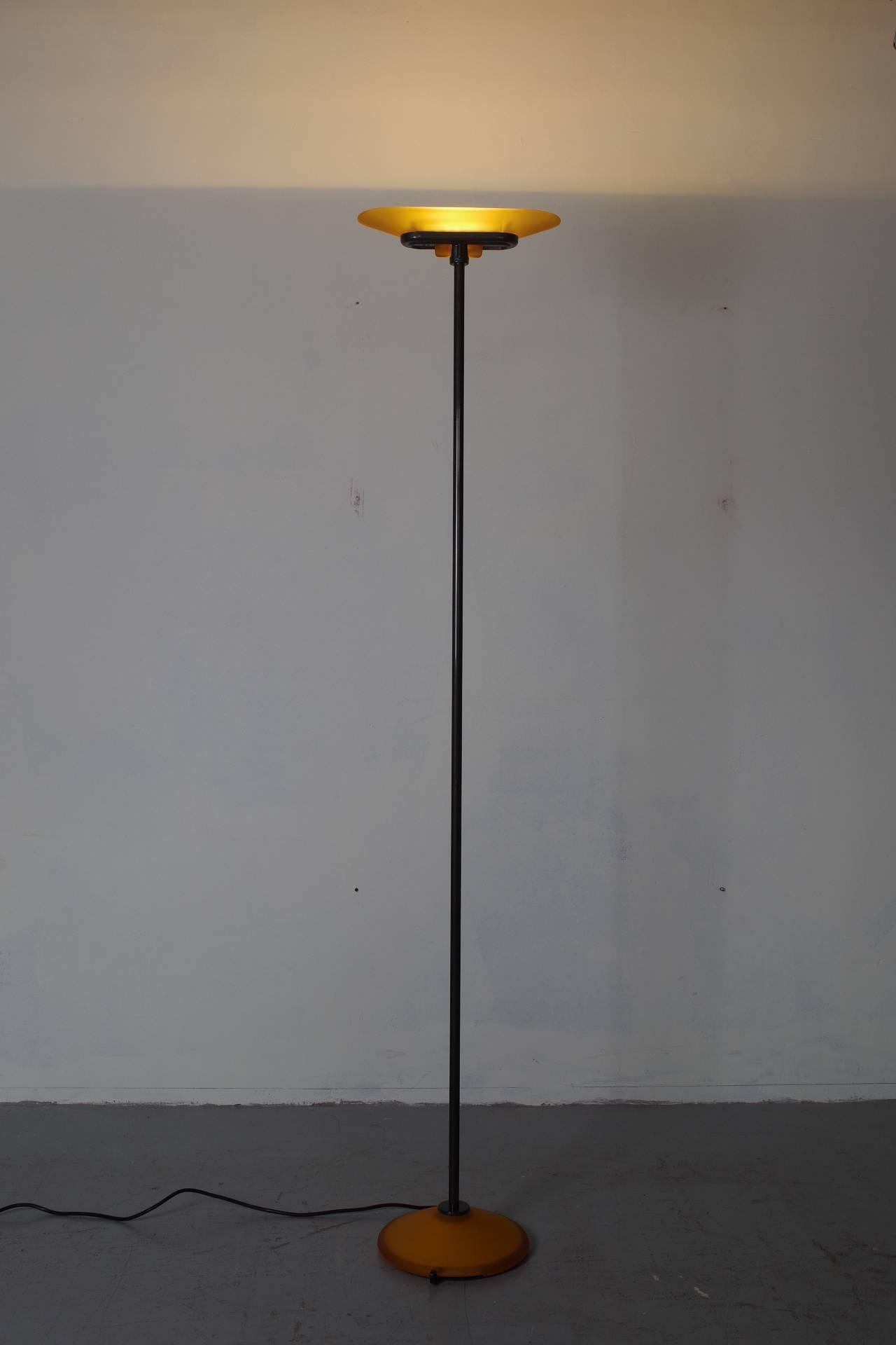 Beautiful stylish uplighter from Artemide with amber glass shade and base. The light can be dimmed by the black handle on the base (see last picture). The iron parts are powder coated in anthracite black.
