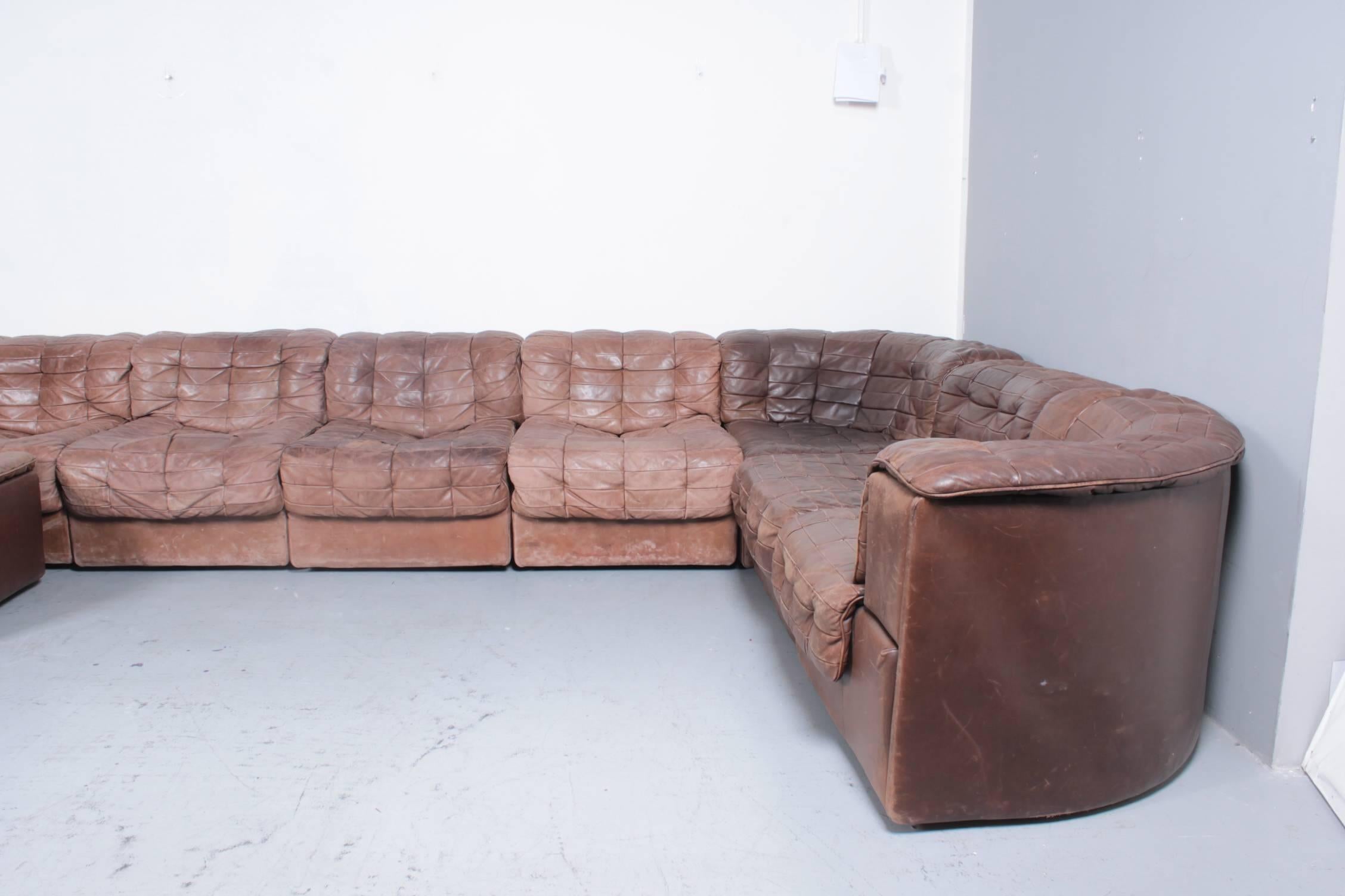 Big seating corner from Swiss manufacturer De Sede model DS11 in original brown patchwork leather. The set consists of ten pieces: one corner, two corner-ends, one ottoman and 6 straight parts. The set is original but can also be treated again with
