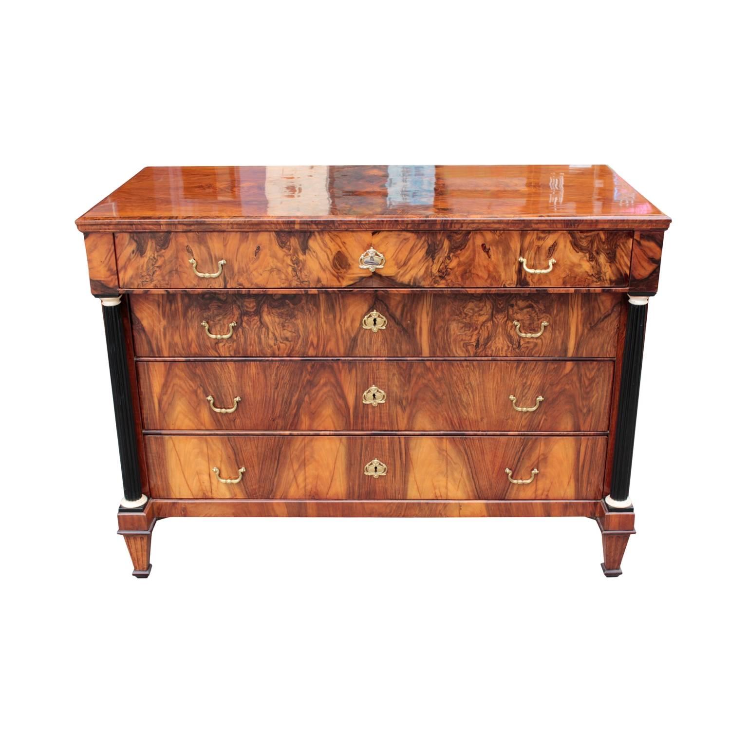 Very fine North Italian neoclassical (Biedermeier period) chest having a frieze drawer on top of three drawers, all fitted with brass urn escutcheons and pulls and flanked by a pair of free-standing ebonized fluted columns with bone capitals and