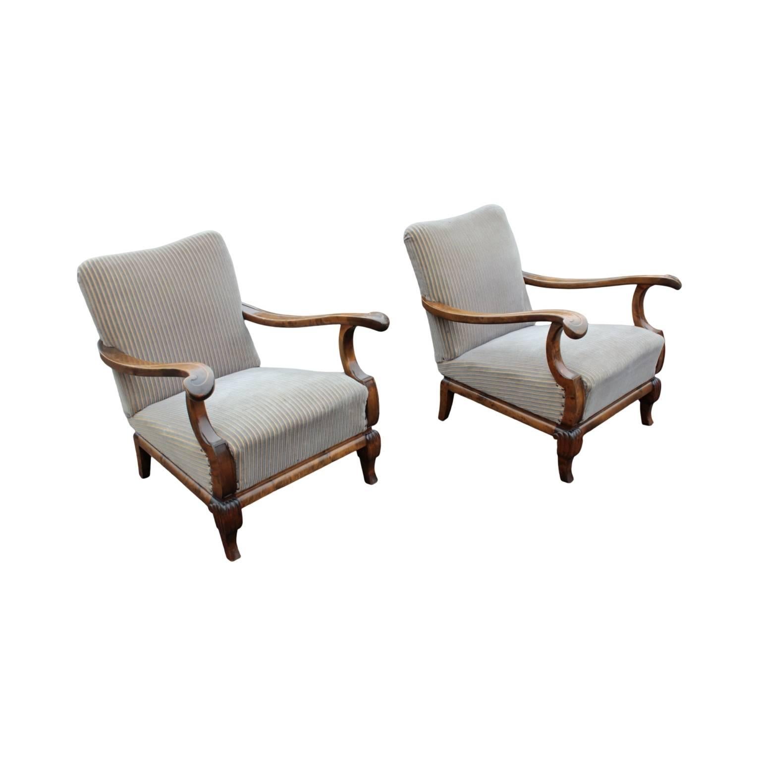 Unusual, elegant and very comfortable pair of arm chairs, each with a padded seat and back having subtly "S" shaped arms ending in carved scrolls with "C" shaped arm supports. Short legs, front pair with carved knees. In flame