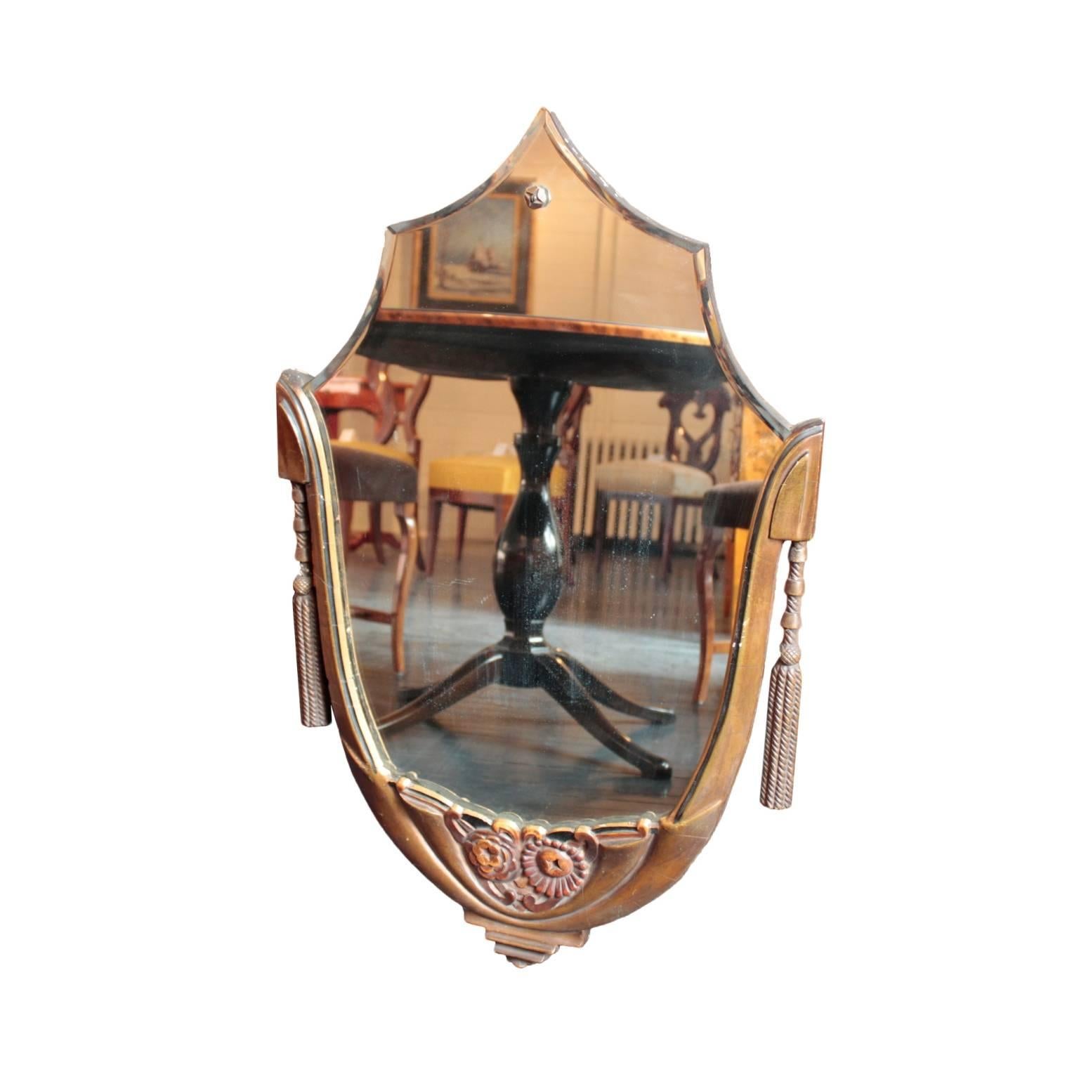 Lyre shaped, bronze color painted and parcel ebonized wooden frame with finely carved tassels, scroll and floral motifs featuring a bud and a bloomed flower. Shaped original beveled mirror plate with a decorative screw at the top.