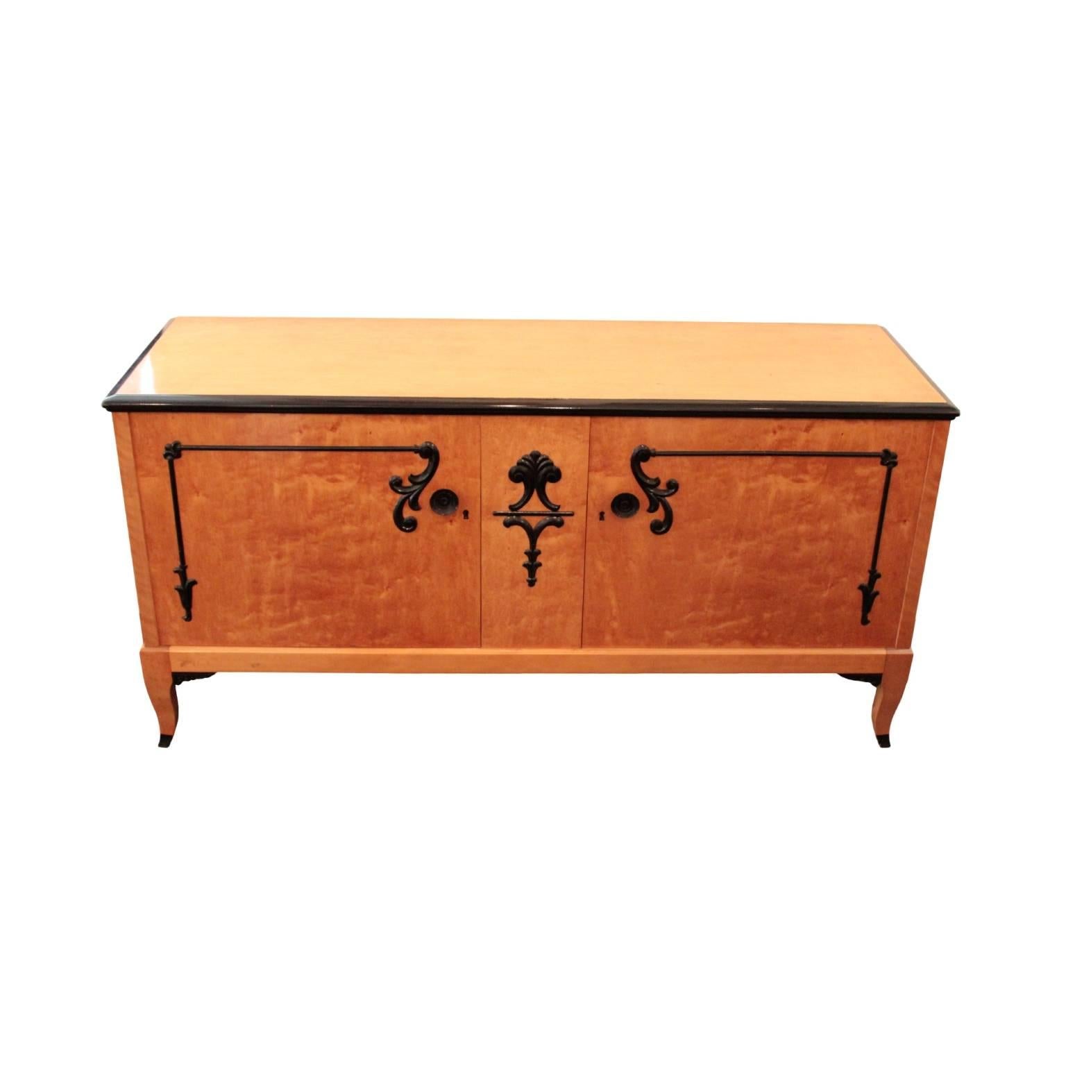 Top with ebonized molded edge resting on a corpus featuring pair of doors and middle segment decorated with ebonized moldings and carvings depicting acanthus and anthemion leaves. Interior in birch, right cabinet with one drawer and storage space;