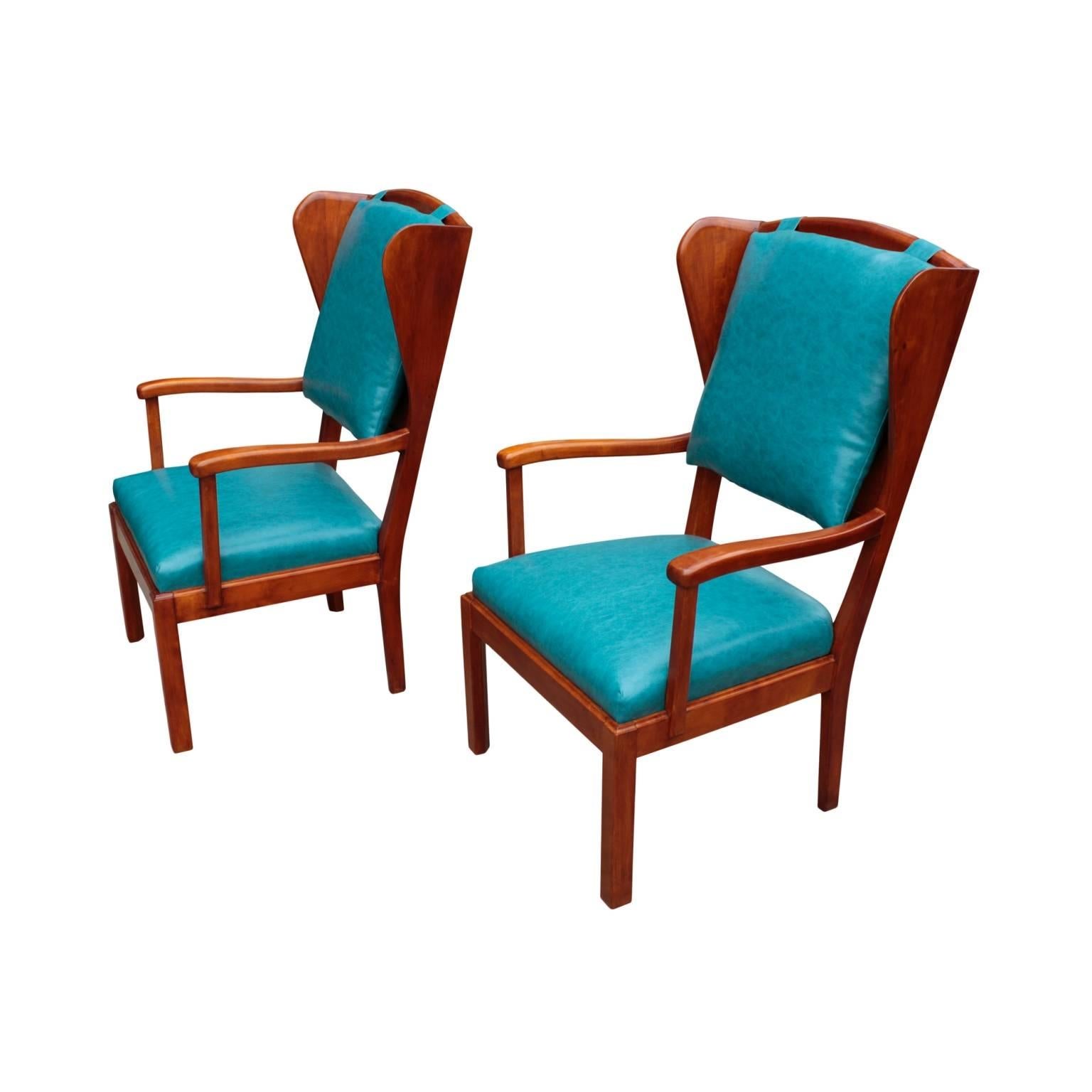 Unusual and comfortable pair of Swedish Functionalism (1930's) wingback armchairs. Padded seats and removable pillows on birch panel backrests recovered with turquoise colored composition leather. Shaped arms and legs in flame birch.