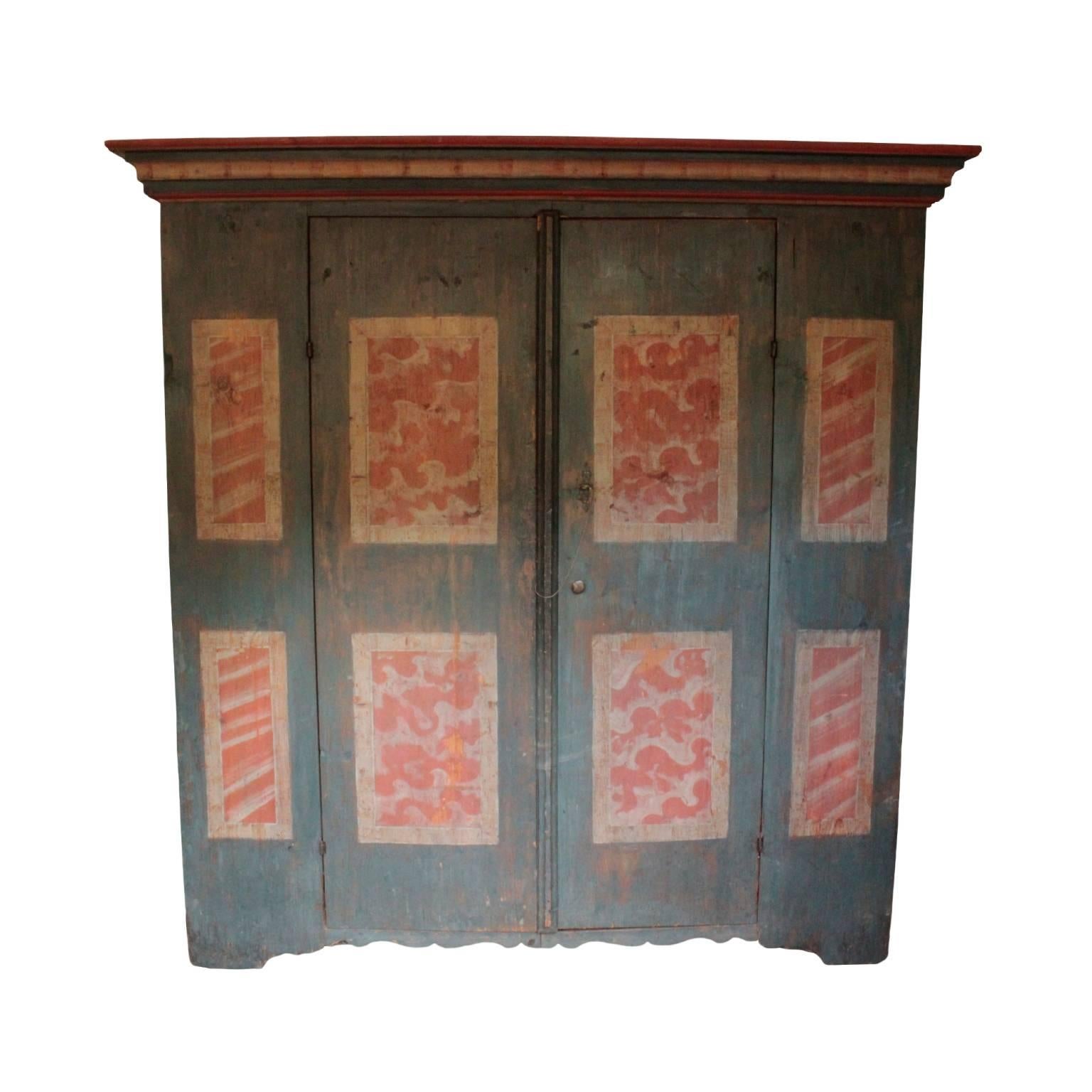 Effervescent Swedish painted cabinet having a pair of doors enclosing three shelves with curvaceous front edges and two bottom drawers with original leather strap pulls. Corresponding curvaceous base. In pine, sponge painted in sea blue, Venetian