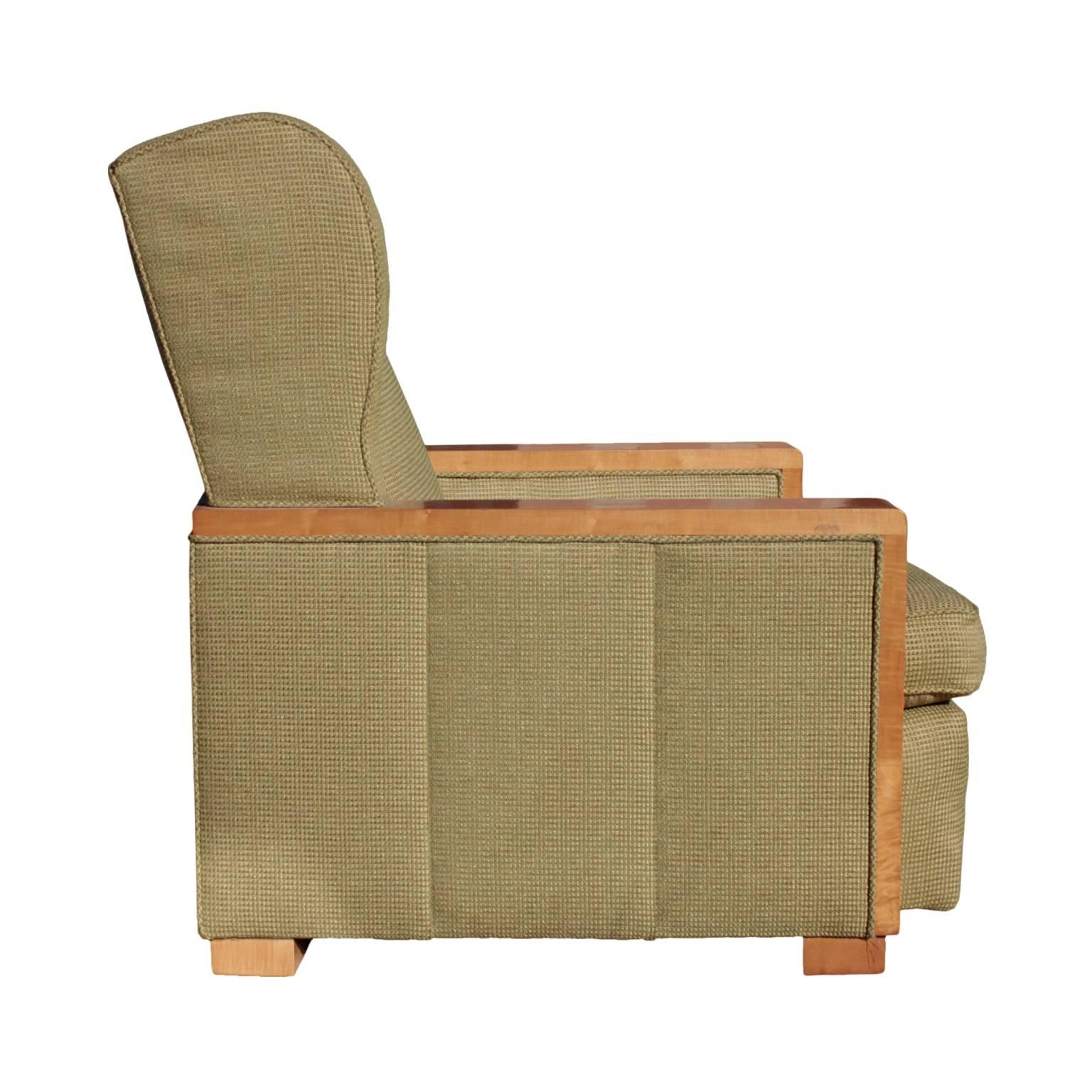 Sculpted, large, solid bergere of cubical design, featuring a box frame in sycamore which wraps around a fully upholstered, winged backrest angled for comfort. Protruding box seat with pillow insert. Resting on block feet in sycamore. 

The chair