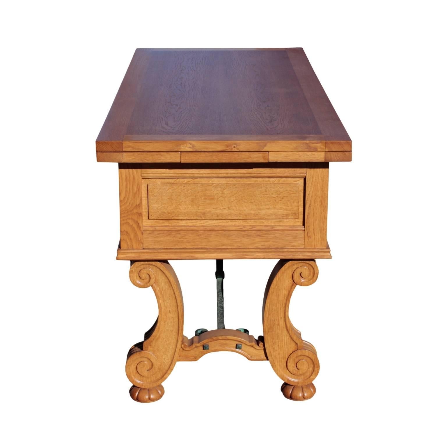 Distinctive banquet table attributed to Jean Charles Moreaux featuring rectangular top with two sliding pull-out extensions resting on a case with three drawers and three faux drawers fitted with verde antico fer forge fleur de lis hardware and