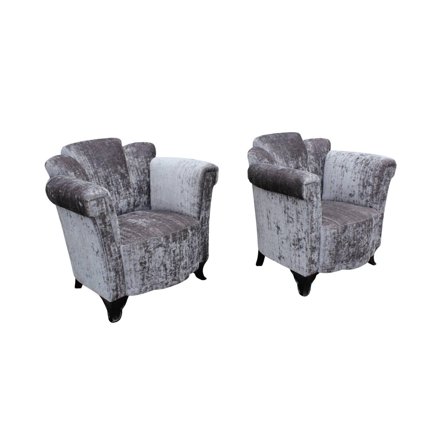Extraordinary pair of early Art Deco period bergeres displaying sculptural quality and of superb comfort; featuring channelled backs, corresponding shaped box seats and elegant tall armrests. Shaped pair of front legs and back sabre legs in dark
