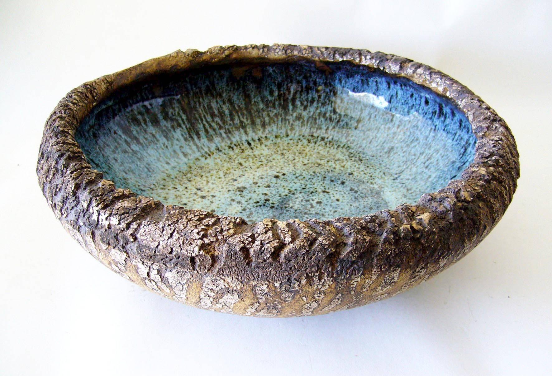 Large-scale low open bowl with cracked, craggy unglazed exterior and a contrasting blue gloss glazed interior. Bowl measures 13