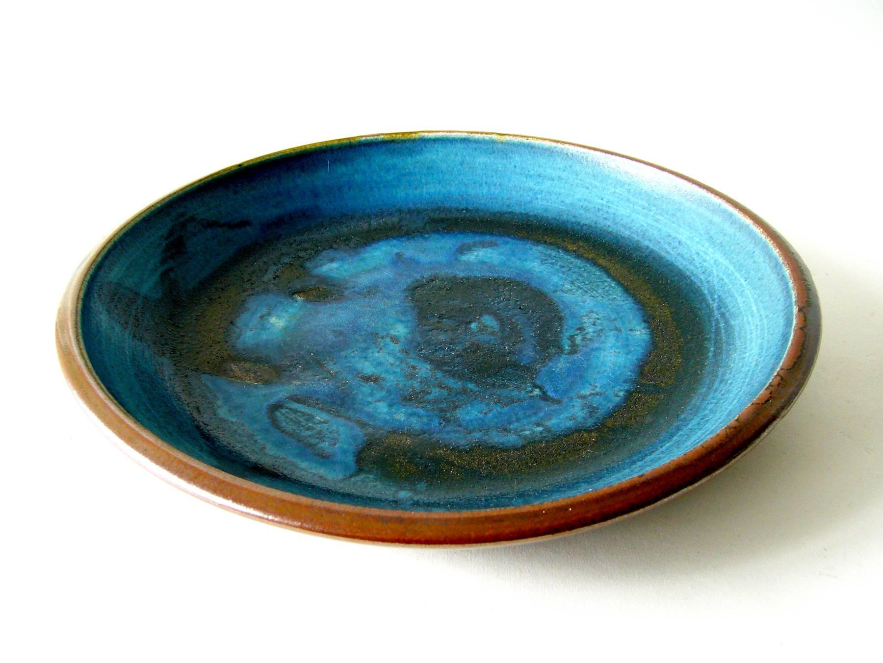 Abstract Expressionist glazed low bowl or charger created by Toshiko Takaezu of Honolulu, Hawaii. Bowl measures 12.5" in diameter by 2" high and is signed with artist's mark of TT beneath. In very good vintage condition.