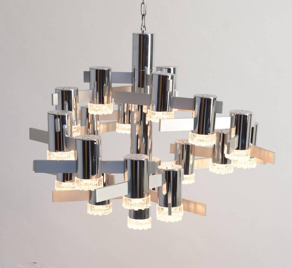 Gaetano Sciolari designed this large sculptural chandelier for Lightolier, Italy in the 1970s. This chandelier is very impressive with 22 lights made of polished chrome, brushed aluminium and glass.
In this design Gaetano Sciolari playfully adapts