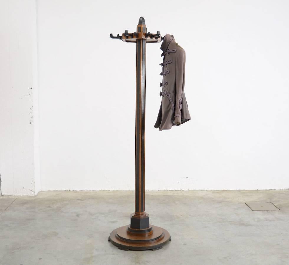 This beautiful Art Deco coat stand in ‘Amsterdamse School’ style can be dated in the early 20th century and is produced in the Netherlands. This expressive design is made of brown natural wood and black lacquered wood. This coat Stand is in very