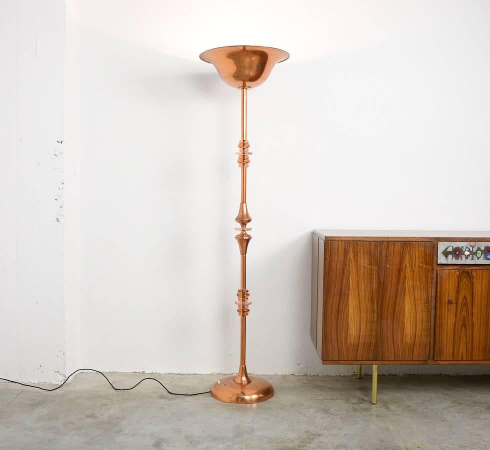 This Art Deco floor lamp is made of red copper and glass. It can be dated in the 1930s.
The stem is built up very gracefully with red copper and glass parts.
The copper shade is nice shaped and white lacquered inside.
It is really a beautiful