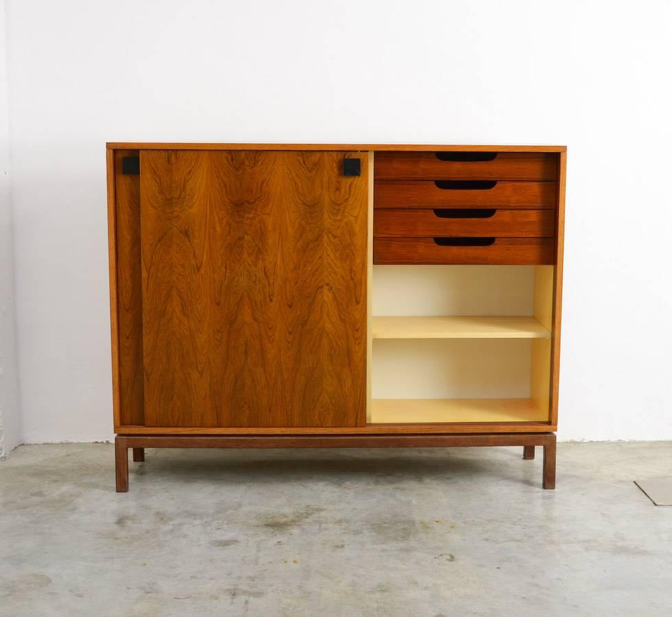 This extraordinary cabinet is a design of Alfred Hendrickx for Belform in the 1960s.
It is a minimal and pure piece of furniture made of high quality materials.
The design of the wood veneer on the two sliding doors is amazing.
The square metal
