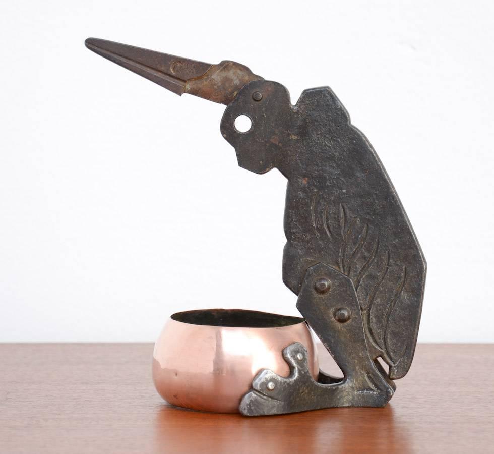 This cigar cutter was designed by the German artist Ignatius Taschner, Germany, circa 1905.
You can put a cigar in the eye of the bird when the beak is opened. When you close the beak it will cut the cigar. The cigar tip will fall into the bin