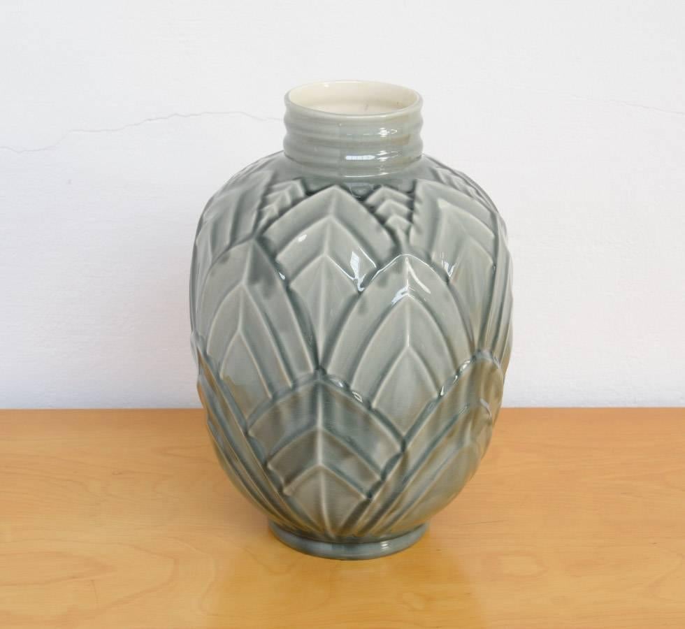 This monochrome vase by Charles Catteau for Boch Frères Keramis can be dated in the 1930s.
The relief decoration with stylized leaves is typical Art Deco. It was executed in different colors.
This vase is in very good condition and numbered on