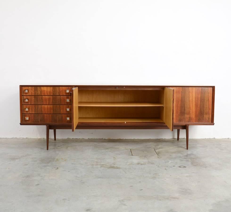 This very nice sideboard is designed by Oswald Vermaercke for V-Form, Belgium in the 1960s. This sideboard in rosewood veneer is a rare edition with nice graphic handles.
This elegant sideboard is in very good vintage condition and marked.