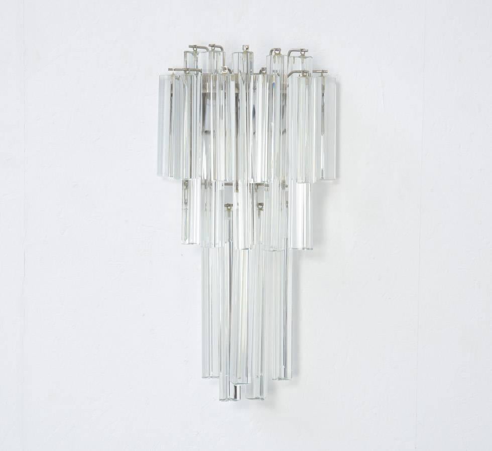 This Venini glass cascading wall lamp is a made of 16 clear crystal glass prisms in two different sizes. It provides a very nice and warm indirect light.
This great wall object and light in one is in excellent condition. It needs two light bulbs.