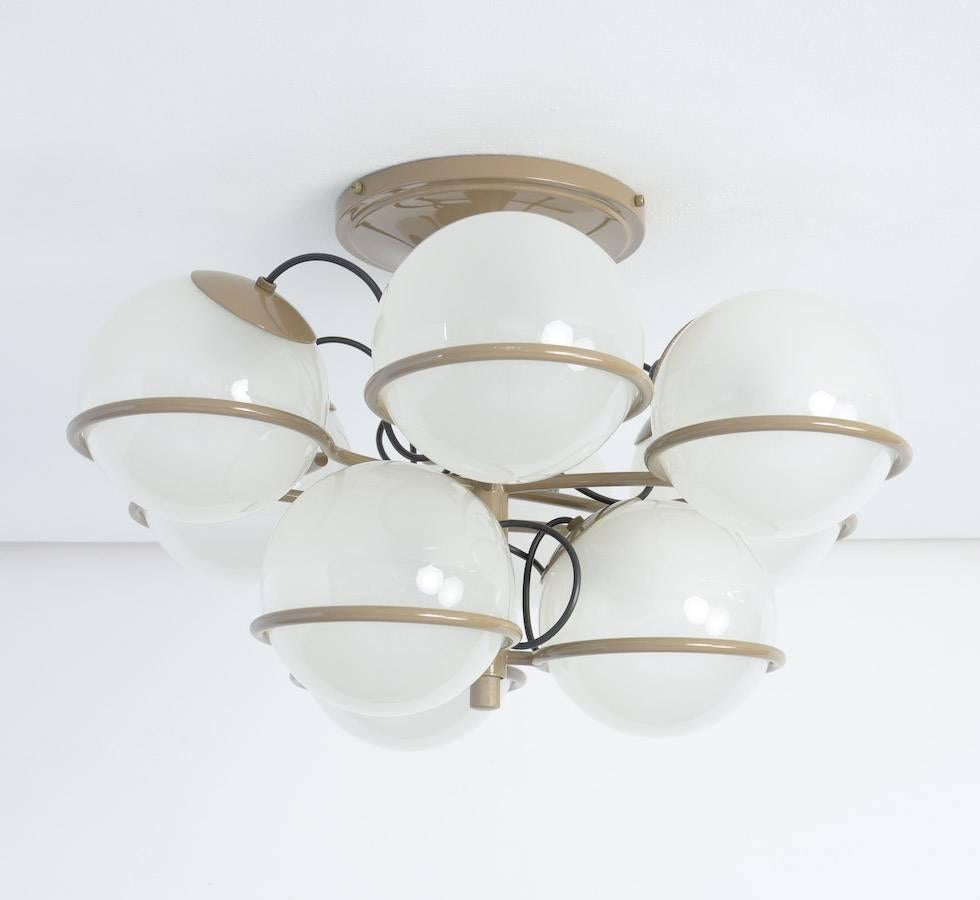 This great ceiling lamp was designed by Gino Sarfatti in 1960 for Arteluce.
The nine spherical diffusers in frosted glass are simply resting on the ring-shaped supports.
The metal parts are lacquered in mustard.
This old ceiling lamp is in very