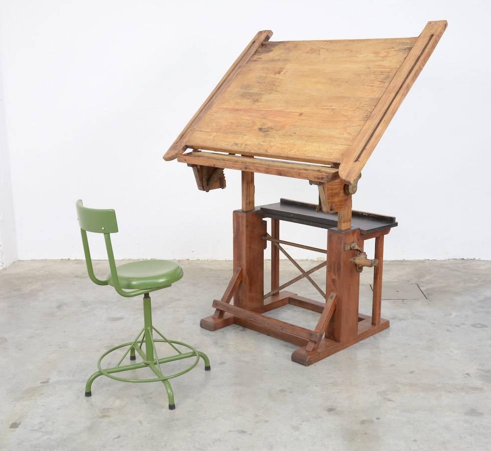 This special industrial drafting table is made of wood with iron details.
It is an impressive and heavy piece.
You can put it easily in many different positions.
This old drafting table is in very good original condition, it is marked Kahn