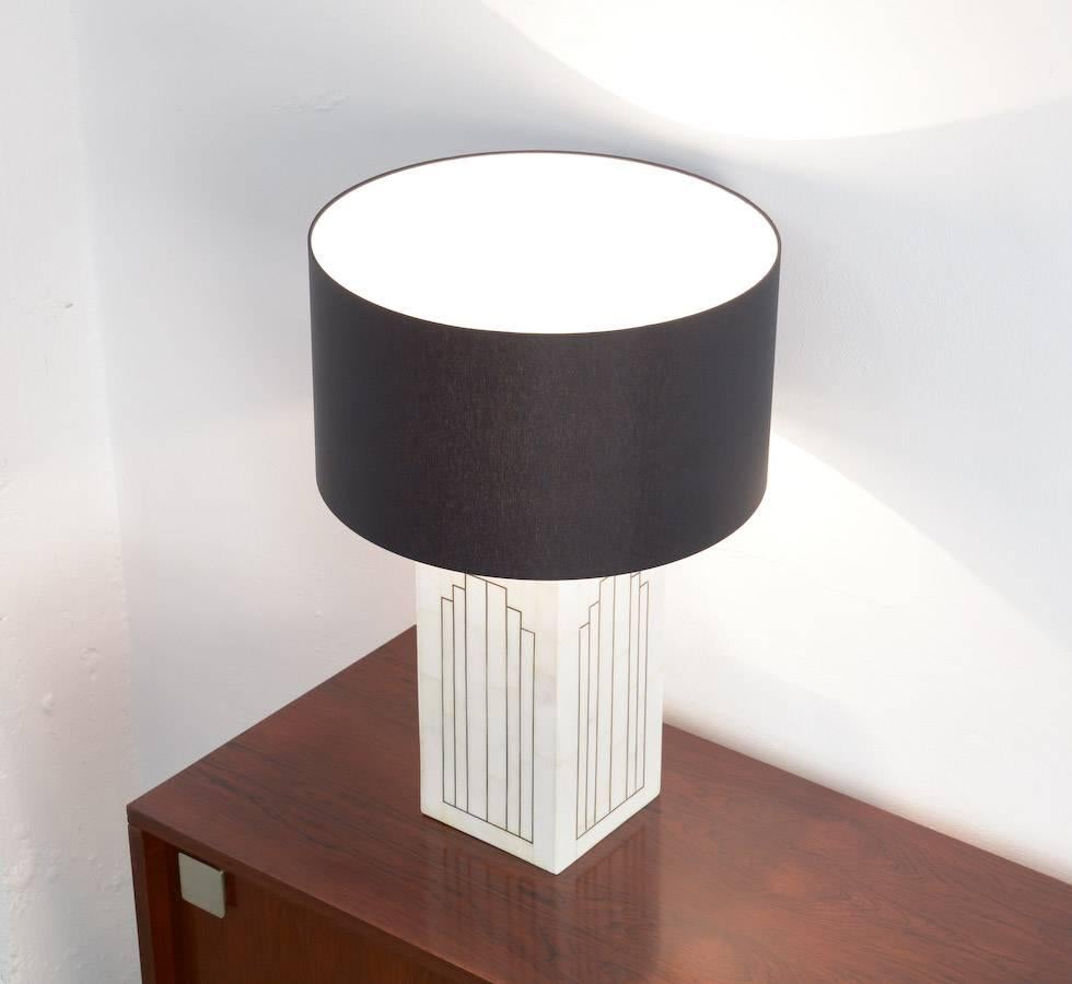This marble table lamp is a design of the 1970s.
The marble mosaic is fixed on a wooden base.
The copper inlay accentuate the geometric design.
This impressive lamp is in very good condition with a new black shade.