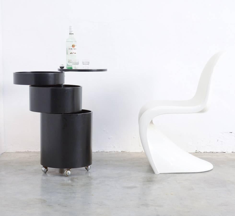 Verner Panton designed the barboy in 1963.
This barboy of black lacquered moulded laminated wood has four chrome casters.
The four-part cylindrical body has two swing-out sections to hold drinks etc.
This barboy is in a very good original