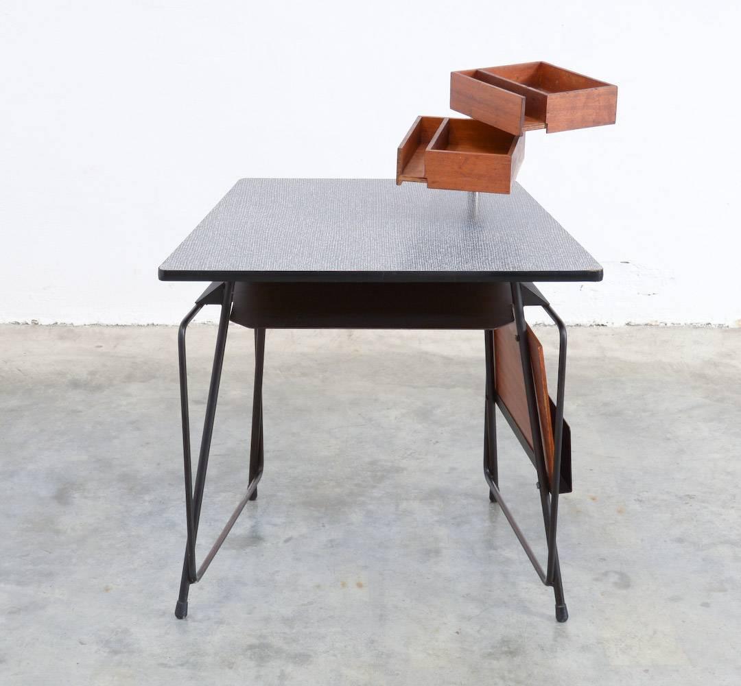 This very rare children’s desk was designed by Willy Van Der Meeren for Tubax in the 1950s.
It is a unique piece, probably measure made for a private client.
The strong black lacquered frame is nice detailed with a wooden magazine rack.
The top,