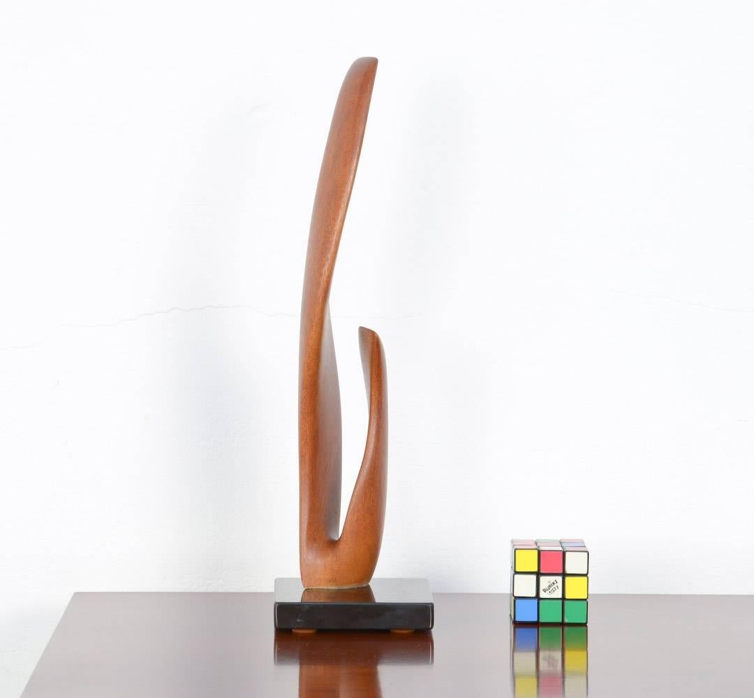 This elegant organic sculpture was created by J. Theys. It is marked.
The abstract organic shape is sculpted in wood and polished. It is asymmetrical fixed on a black marble base.
This sculpture is in perfect condition.
